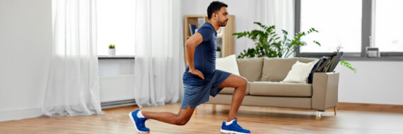 Man performing a reverse lunge at home, illustrating a physical therapy exercise for chondromalacia patella recovery.