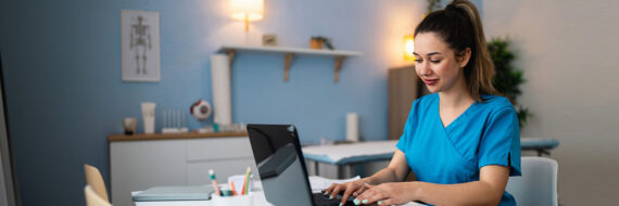 Therapist reviewing CPT codes for PT and OT billing on a laptop in a modern clinic office.