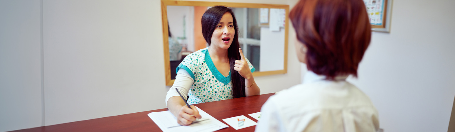 Speech-language pathologist working with a patient on verbal articulation, demonstrating techniques related to SLP CPT codes and accurate therapy documentation.