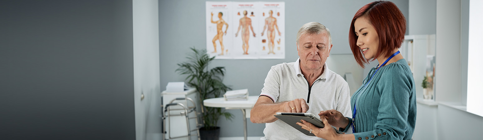 Healthcare provider guiding a patient through treatment options on a digital device.