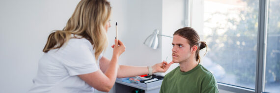 Healthcare professional performing an eye-tracking test on a young patient to assess post-concussion syndrome.