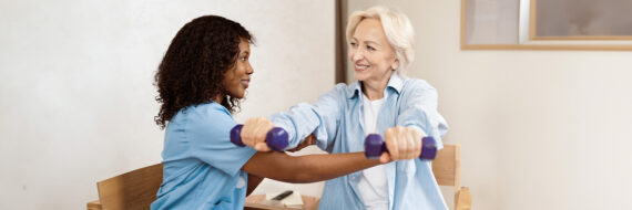 Occupational therapist assisting an older adult with strength exercises using hand weights during therapy.