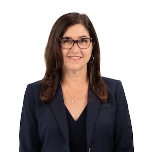 A woman in glasses and a navy blazer represents Medbridge's future of digital healthcare.