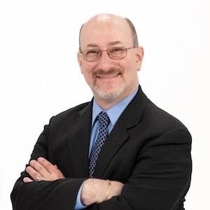A confident professional in a suit and glasses represents medbridge's digital healthcare expertise.